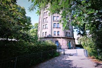 a building with a clock tower in the middle of a park
