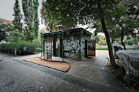 a graffiti covered bus stop in a park