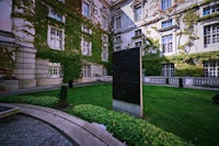 a statue in front of a building with ivy growing around it