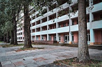 a building with a sidewalk and trees