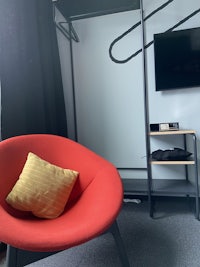 a room with a red chair and a tv
