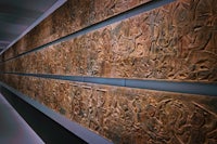 a large wall of carvings in a museum