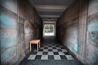 a hallway with a bench and a checkered floor