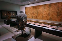 a buddha head is on display in a museum