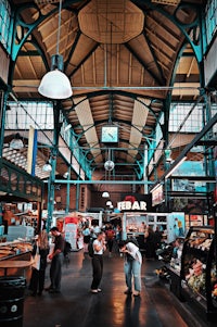 a large indoor market with lots of people walking around