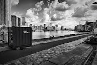 a black and white photo of a container on the side of a river