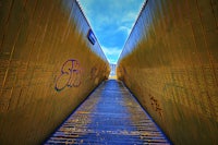 a wooden walkway with graffiti on it