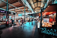 a crowd of people walking through a market