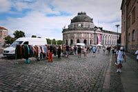 a crowd of people standing on a cobblestone street