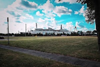 a park with a factory in the background