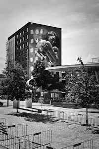 a black and white photo of a building with a woman on it